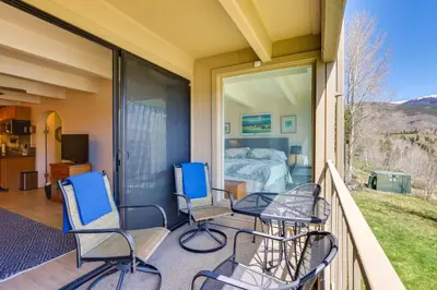 a balcony with chairs and a bed and a bedroom at Mtn and Reservoir Views Cozy Dillon Condo! in Dillon
