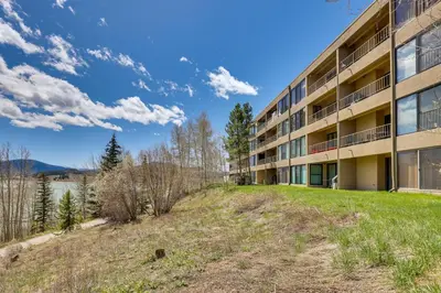 an apartment building with a green lawn in front of it at Mtn and Reservoir Views Cozy Dillon Condo! in Dillon
