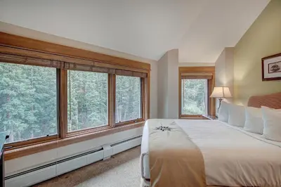 a bedroom with a bed and large windows at Luxurious 2 BR in River Run Village with Ski in ski out condo in Dillon
