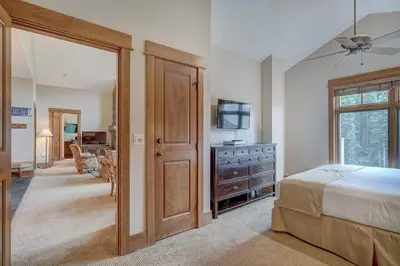 a bedroom with a bed and a dresser with a television at Luxurious 2 BR in River Run Village with Ski in ski out condo in Dillon