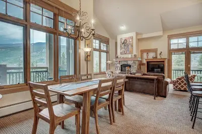 a dining room with a table and chairs and a fireplace at Luxurious 3 BR in River Run Village Featuring Ski in, ski out condo in Dillon