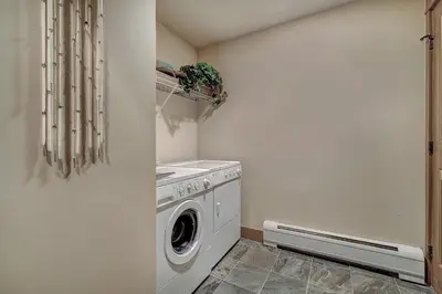 a laundry room with a washing machine and a washer at Luxurious 3 BR in River Run Village Featuring Ski in, ski out condo in Dillon