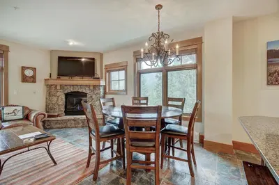 a dining room with a table and a fireplace at Luxurious 2 BR in River Run Village Featuring Ski in ski-out condo in Dillon