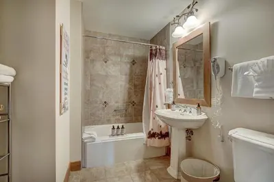 a bathroom with a sink and a toilet and a tub and a sink at Luxurious 2 BR in River Run Village Featuring Ski in ski-out condo in Dillon