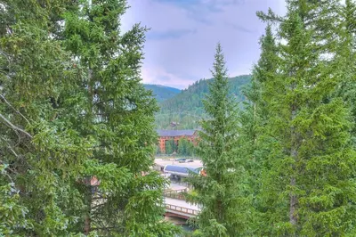 a train on a track between two trees at Luxurious 2 BR in River Run Village Featuring Ski in ski-out condo in Dillon