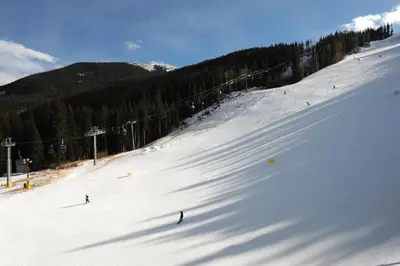 a group of people skiing down a snow covered slope at Luxurious 2 BR in River Run Village Featuring Ski in ski-out condo in Dillon
