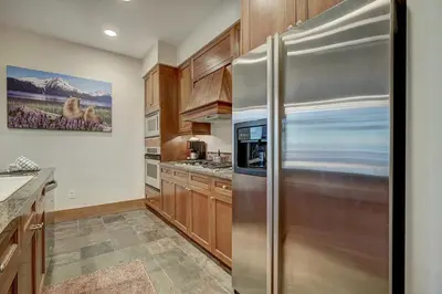 a kitchen with a stainless steel refrigerator at Luxurious 2 BR in River Run Village Featuring Ski in ski-out condo in Dillon