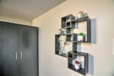 a wall mounted shelf with plants and vases on it at Fresh Downtown Longmont Apartment - Walk to Main! in Longmont