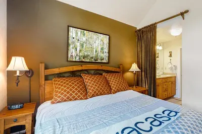 a bedroom with a large bed and a sink at Seasons 1840 in Keystone
