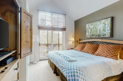 a bedroom with a bed and a tv and a window at Seasons 1840 in Keystone
