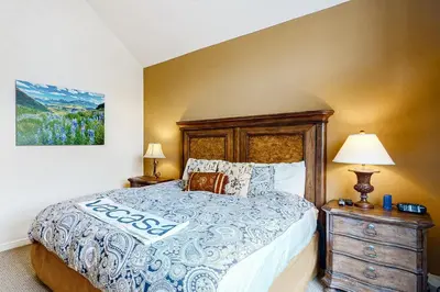 a bedroom with a bed with a wooden headboard and a dresser at Seasons 1840 in Keystone