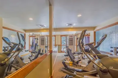 a gym with treadmills and elliptical machines at Beautiful 3 Bedroom Mountain Condo In River Run Village With Hot Tub Access And Walking Distance To The Gondola in Keystone