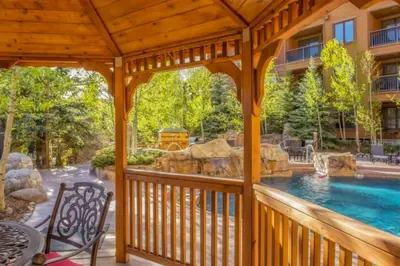 a wooden gazebo with a swimming pool at Beautiful 3 Bedroom Mountain Condo In River Run Village With Hot Tub Access And Walking Distance To The Gondola in Keystone