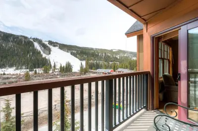 a balcony with a view of a snow covered mountain at Beautiful 1 Bedroom Mountain Condo In River Run Village With Hot Tub Access And Walking Distance To The Gondola in Keystone