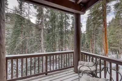 a screened in porch with a bench on the deck at Charming Condo Nestled In The East Keystone Resort Neighborhood, Shuttle To Ski Slopes, Outdoor Pool And Hot Tub in Dillon
