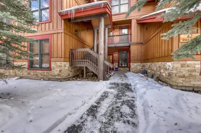 a house with snow on the ground in front of it at Charming Condo Nestled In The East Keystone Resort Neighborhood, Shuttle To Ski Slopes, Outdoor Pool And Hot Tub in Dillon