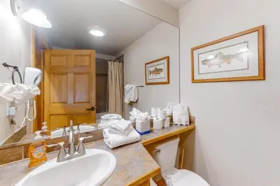 a bathroom with a sink and a toilet and a mirror at Charming Condo Nestled In The East Keystone Resort Neighborhood, Shuttle To Ski Slopes, Outdoor Pool And Hot Tub in Dillon