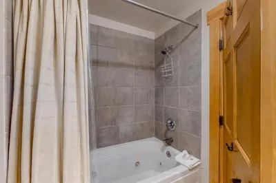 a bathroom with a tub and a shower curtain at Charming Condo Nestled In The East Keystone Resort Neighborhood, Shuttle To Ski Slopes, Outdoor Pool And Hot Tub in Dillon