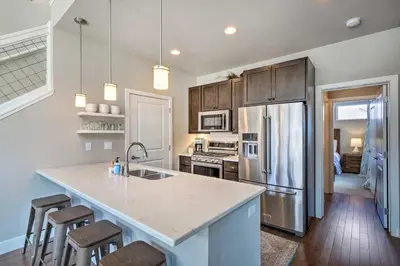 a kitchen with a refrigerator and a counter top at Rendezvous Buckhorn Cabin By Hiking Trails in Winter Park