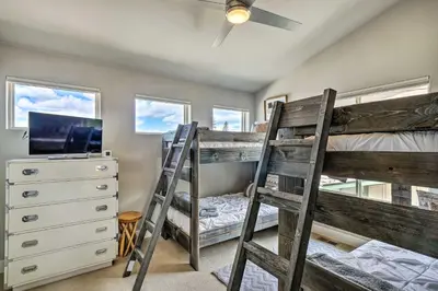 a bedroom with two bunk beds and a tv at Rendezvous Buckhorn Cabin By Hiking Trails in Winter Park