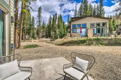 a patio with two chairs and a house at Rendezvous Buckhorn Cabin By Hiking Trails in Winter Park