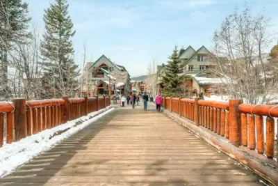a bridge with people walking on it in the snow at Lakeside Village 3 Bedroom Townhome At The Seasons In Keystone in Dillon