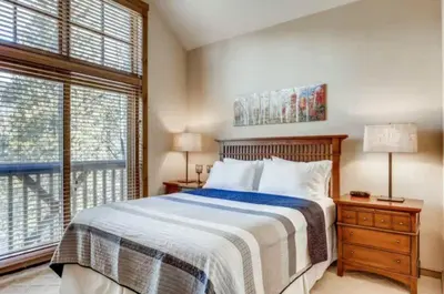 a bedroom with a bed and a large window at Lakeside Village 3 Bedroom Townhome At The Seasons In Keystone in Dillon