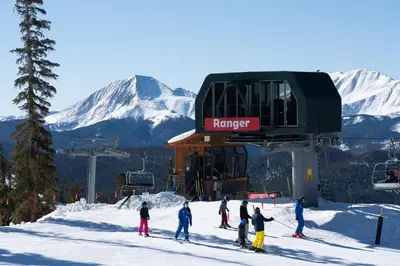a group of people on skis in front of a ski lift at Red Hawk Townhomes 2 Bedroom Rental In River Run Village in Dillon
