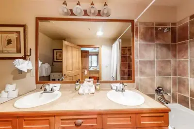 a bathroom with two sinks and a large mirror at Red Hawk Townhomes 2 Bedroom Rental In River Run Village in Dillon
