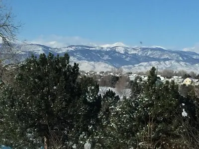 a snow covered mountain range in the distance with trees at 1 or 2 bedrooms with bath at Indian Peaks golf course in Lafayette