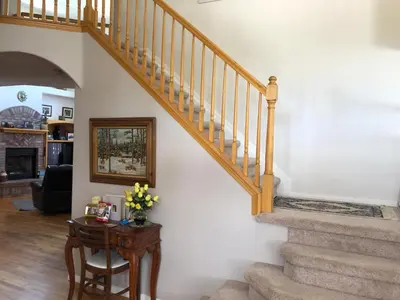 a living room with a staircase and a table with flowers at 1 or 2 bedrooms with bath at Indian Peaks golf course in Lafayette