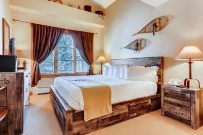 a bedroom with a large bed and a large window at Beautiful 2 Bedroom Mountain Condo In River Run Village With Hot Tub Access And Walking Distance To The Gondola in Keystone