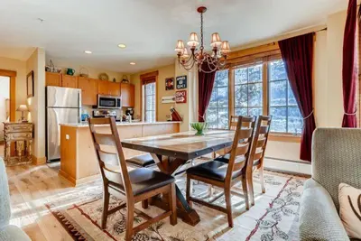 a kitchen and dining room with a table and chairs at Beautiful 2 Bedroom Mountain Condo In River Run Village With Hot Tub Access And Walking Distance To The Gondola in Keystone