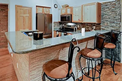 a kitchen with two stools at a kitchen counter at Family Friendly 3 Bedroom Vacation Rental In West Keystone Resort Along The Snake River With Pool And Hot Tub in Keystone