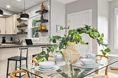 a dining room with a glass table with a vase at Spacious Downtown Apartment - Walk to Old Town FC! in Fort Collins