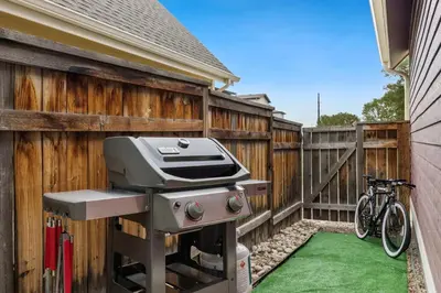 a grill on a fence next to a bike at Mid-century Mod Retreat near Old Town - Free Bikes in Fort Collins