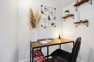 a desk in a room with a vase and a chair at Mid-century Mod Retreat near Old Town - Free Bikes in Fort Collins