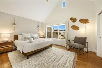 a bedroom with a bed and a window and a chair at Mid-century Mod Retreat near Old Town - Free Bikes in Fort Collins