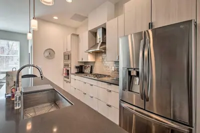 a kitchen with a stainless steel refrigerator and a sink at Rooftop Deck and City Views Denver Abode! in Denver