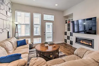 a living room with a couch and a table and a fireplace at Rooftop Deck and City Views Denver Abode! in Denver