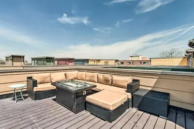 a patio with a couch and a table on a roof at Rooftop Deck and City Views Denver Abode! in Denver