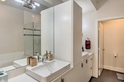 a white bathroom with a sink and a shower at Rooftop Deck and City Views Denver Abode! in Denver