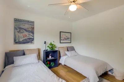 two beds in a room with a ceiling fan at The Modern Ridge House with Yard in Wheat Ridge in Wheat Ridge