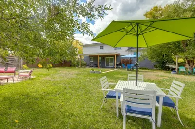 a table and chairs with a green umbrella at The Modern Ridge House with Yard in Wheat Ridge in Wheat Ridge