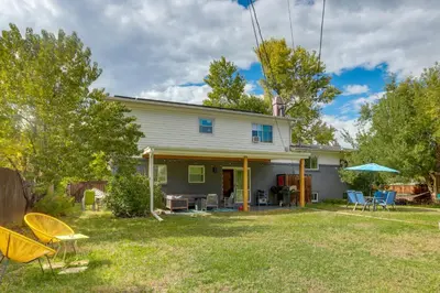 a house with a yard with chairs and tables at The Modern Ridge House with Yard in Wheat Ridge in Wheat Ridge