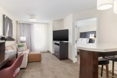 a hotel suite with a living room with a bed at Staybridge Suites Denver - Central Park by IHG in Denver