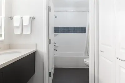 a white bathroom with a shower and a toilet at Staybridge Suites Denver - Central Park by IHG in Denver
