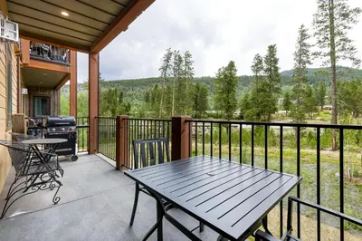 a screened porch with a picnic table and a grill at 202 Clearwater Lofts condo in Keystone