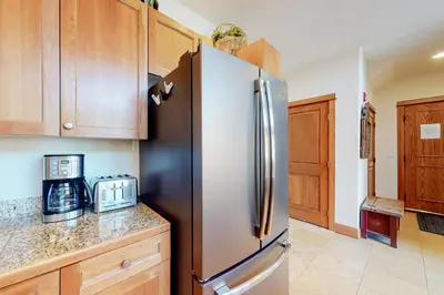 a kitchen with a stainless steel refrigerator and wooden cabinets at Antlers Gulch #304 in Keystone