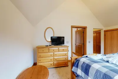 a bedroom with a bed and a dresser with a mirror at Antlers Gulch #304 in Keystone
